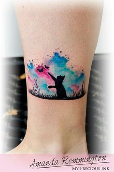 a cat tattoo on the ankle with watercolor clouds and stars in the sky behind it