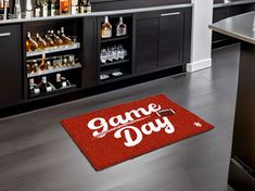 a red door mat with the words game day on it in front of a bar