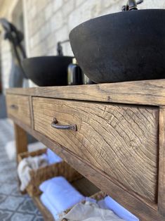 an old wooden table with two bowls on it and some napkins in the drawer