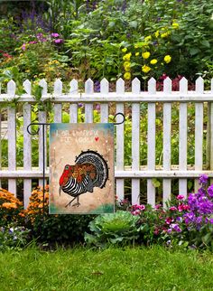 there is a sign on the fence in front of flowers