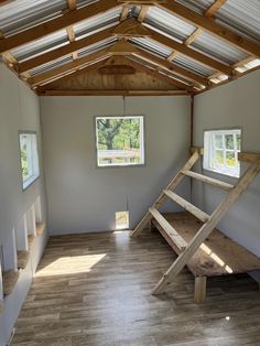 an empty room with wooden stairs and windows