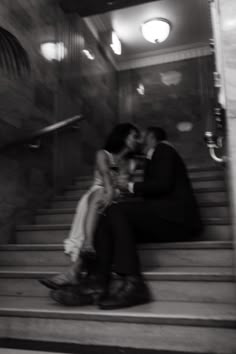 a man and woman sitting on some stairs