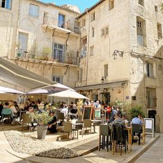 people are sitting at tables in an outdoor cafe