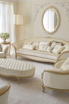 a living room with white couches and chairs in front of a round mirror on the wall