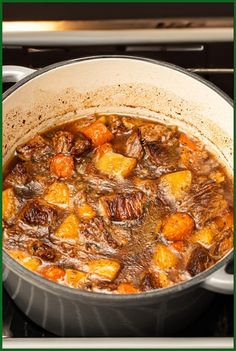 a pot filled with stew sitting on top of a stove