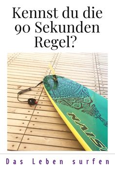 a surfboard laying on top of a wooden floor next to a mouse and wires