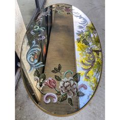 a round glass table with flowers painted on it