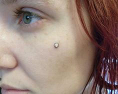 a woman with piercings on her nose looking at the camera