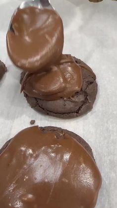 three cookies with chocolate frosting and a spoon