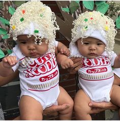 two babies wearing coca cola hats and holding their hands up in front of the camera