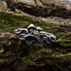 a silver ring sitting on top of a moss covered rock