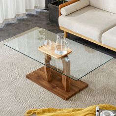 a living room with a couch, coffee table and vases on the floor next to it