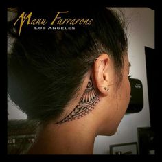 the back of a woman's ear with an intricate tattoo design on her left side