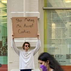 a man holding up a sign that says stop making me accept cookies