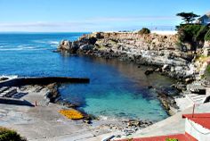 the ocean is clear and blue as it sits next to some buildings with red roof tops