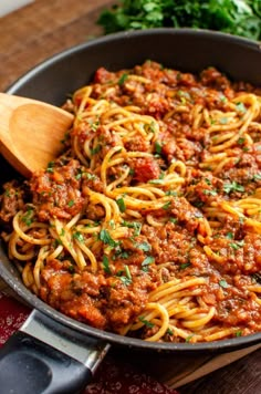 a skillet filled with spaghetti and meat sauce