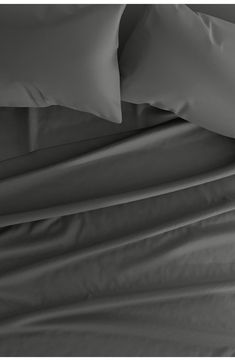 an unmade bed with white sheets and pillowcases on top of each other