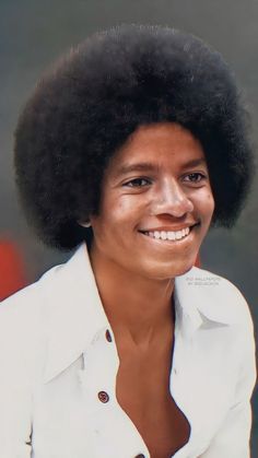 a woman with an afro is smiling for the camera