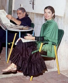 two people sitting at a table reading newspapers