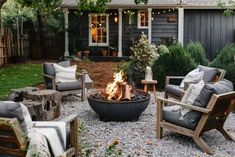 an outdoor fire pit surrounded by chairs and pillows