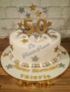 a 50th birthday cake with gold stars and white frosting