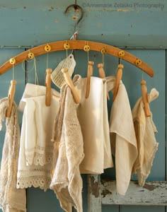 several white towels hanging from a rack on a blue wooden wall with an old door in the background