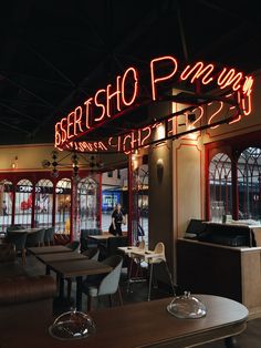 the interior of a restaurant with tables and chairs in front of large neon sign that reads, bersho pine way