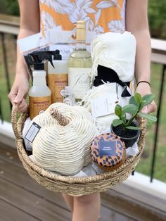 a woman holding a wicker basket filled with skin care products and personal care items