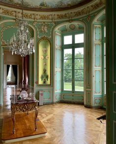 an ornately decorated room with chandelier and large windows