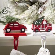 two ornaments are hanging on a window sill