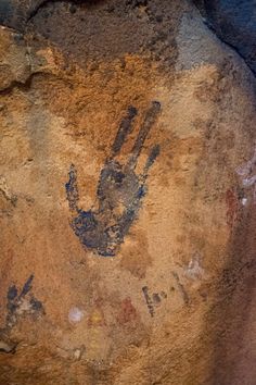 an image of a hand print on the side of a rock