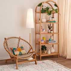 a living room with a chair, bookshelf and potted plants