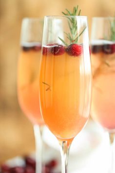 two glasses filled with liquid and garnished with berries