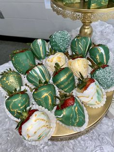 chocolate covered strawberries on a gold platter with green and white frosted decorations