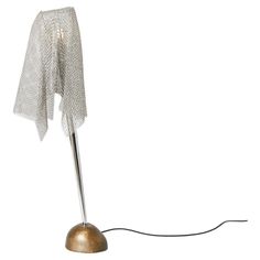 a table lamp with a white cloth draped over it's base and a light bulb plugged in