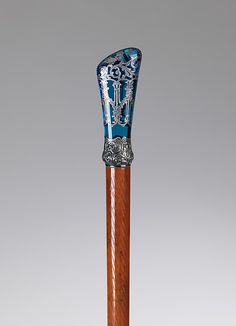 a blue and white vase sitting on top of a wooden stick in front of a gray background