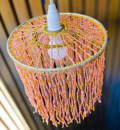 a pink and yellow chandelier with beads hanging from it's centerpiece