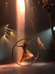 two circus performers are performing with hoop rings