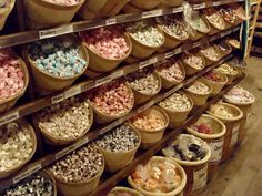 the shelves are filled with many different types of snacks and treats in baskets on them