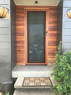 the front door of a house with two lights above it and a planter on the side