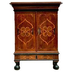 an old wooden cabinet with two doors and carvings on the front, sitting against a white background