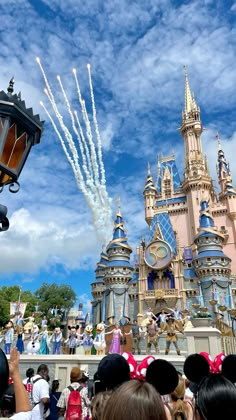 people watching fireworks in the sky over a castle at disney world with their heads turned to look like they're on fire