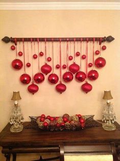 red ornaments are hanging on the wall above a table