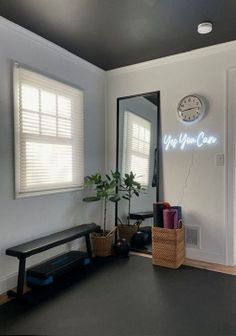 a room with a mirror, bench and clock on the wall next to a door