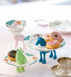 there are three plates that have donuts on them and one has a horse figurine