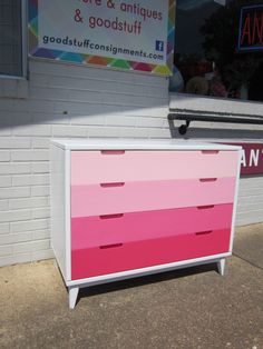 a pink and white dresser sitting on the sidewalk