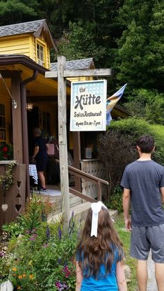 two people are walking towards a small restaurant