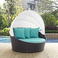 an outdoor lounge chair with blue pillows on it