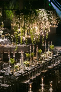 a long table is set up with tall centerpieces and flowers in vases