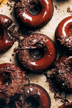 chocolate doughnuts with white frosting and sprinkles on a baking sheet